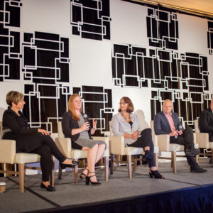 Five people on stage answering questions at the FINEOS Global Summit in 2017