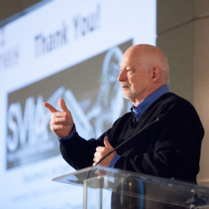 A man pointing and speaking at the FINEOS Global Summit in 2017