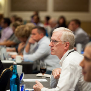 A man wearing glasses listening and concentrating at the FINEOS Global Summit in 2017