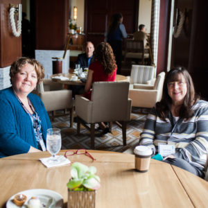 Two women resting and posing for a photo during a break at the FINEOS Global Summit in 2017