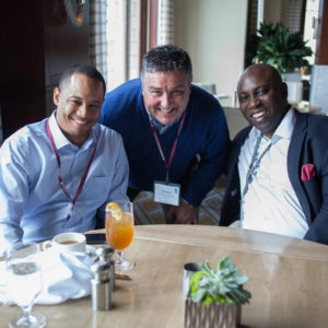 Three happy men pose for a photo at FINEOS Global Summit in 2017
