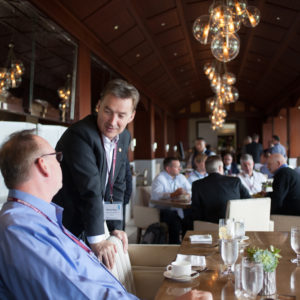 Two men in suits talking to each other at FINEOS Global Summit in 2017