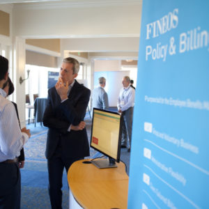 A man listening intently to a person speaking at the FINEOS Global Summit in 2017